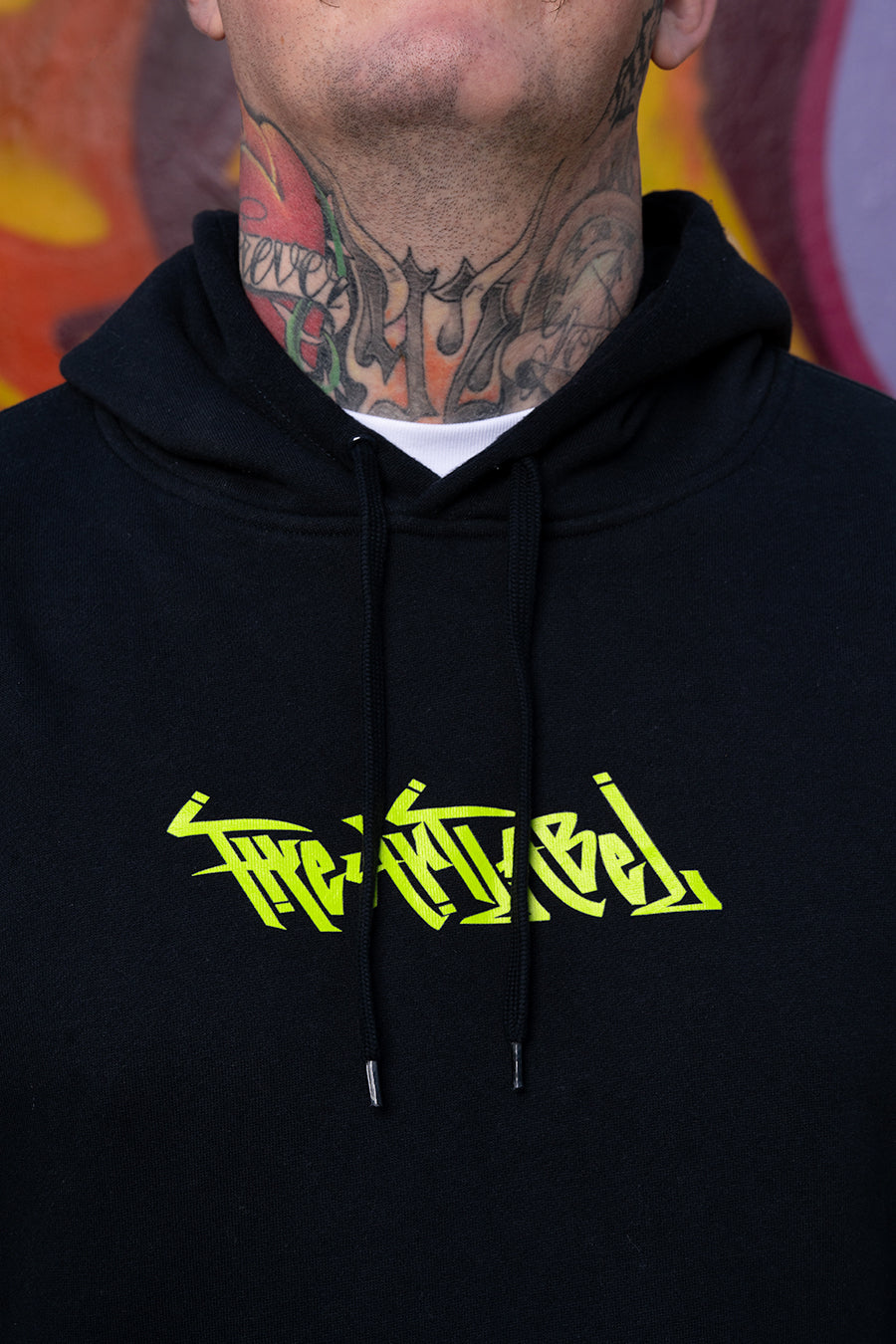 A picture of a guy from chin to stomach showing the front of his hoodie saying 'THE ART LABEL' and showing neck tattoos