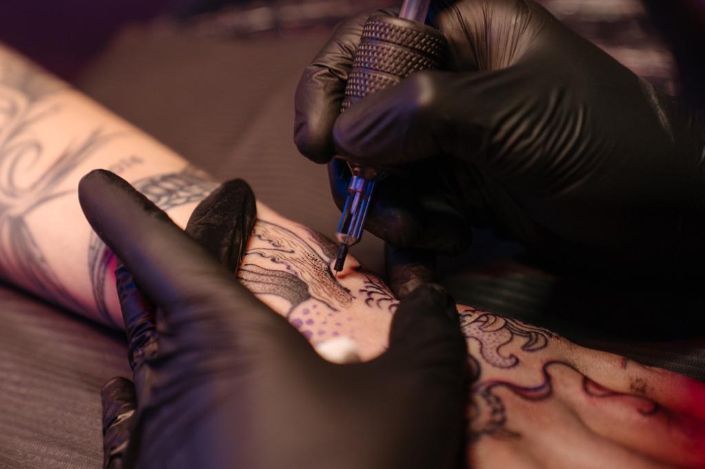 A Person Tattooing someone's wrist 