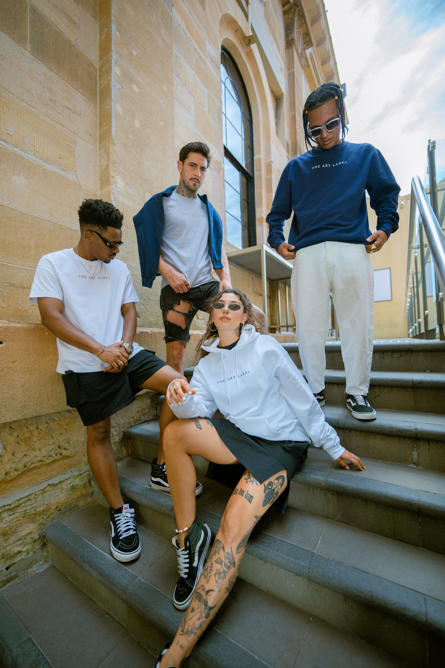 A group of people posing on an outdoor staircase while wearing wearable art from THE ART LABEL
